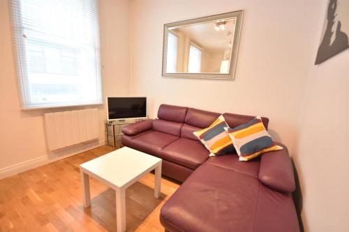 - un salon avec un canapé et une table dans l'établissement Apt 2, Soho Apartments 1st floor by Indigo Flats, à Londres