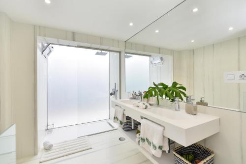 a white bathroom with a sink and a shower at Maspalomas Beach apartment La Charca III in Maspalomas