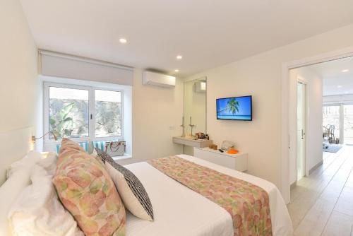 ein Schlafzimmer mit einem großen weißen Bett mit Kissen in der Unterkunft Maspalomas Beach apartment La Charca III in Maspalomas