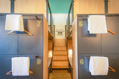 a locker room with two white towels and a staircase at Sparks Hostel in Rotterdam