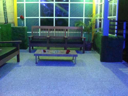 a living room with two benches and a coffee table at Hotel Abhinandan Grand in Dehradun