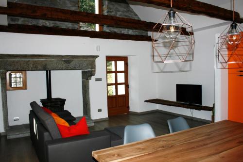 a living room with a table and a fireplace at Ca’ Süler in Crevoladossola