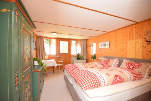 - une chambre avec un lit doté d'oreillers rouges et blancs dans l'établissement Studio bim Chalet bim Chilchli, à Mürren