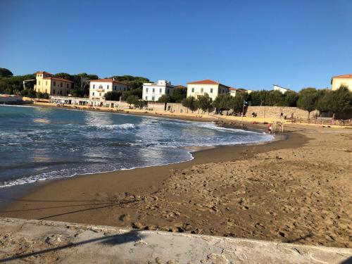 a beach with a group of houses and the ocean at Casa in campagna a due passi dal mare in Pisa