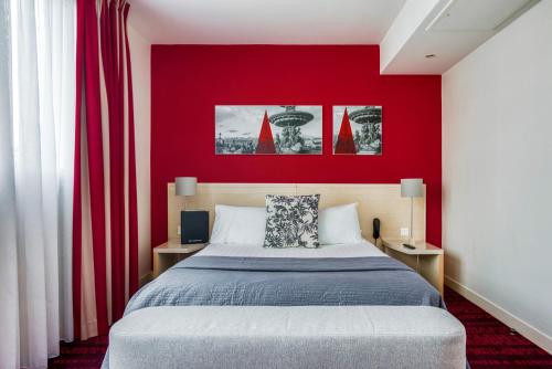 a bedroom with a red wall and a bed at Hotel Le Richemont in Paris