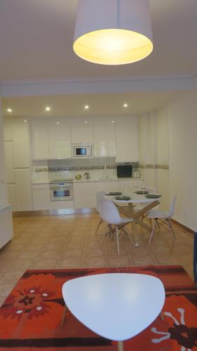 a living room with a table and chairs and a kitchen at Palacio Azcárate Hotel in Ezcaray