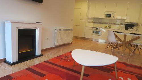 a living room with a fireplace and a table and chairs at Palacio Azcárate Hotel in Ezcaray