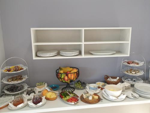 a shelf filled with plates and bowls of food at Villa Ljiljana in Vinkovci