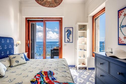 a bedroom with a bed with a view of the ocean at RELAIS TRITONE in Nerano