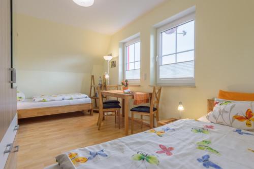 a bedroom with two beds and a table and a desk at Ferienhaus Rotmilan in Vieregge