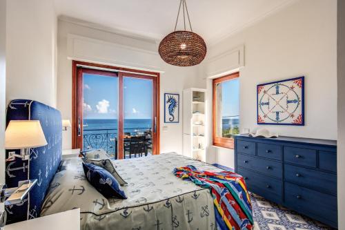 a bedroom with a blue bed and a view of the ocean at RELAIS TRITONE in Nerano