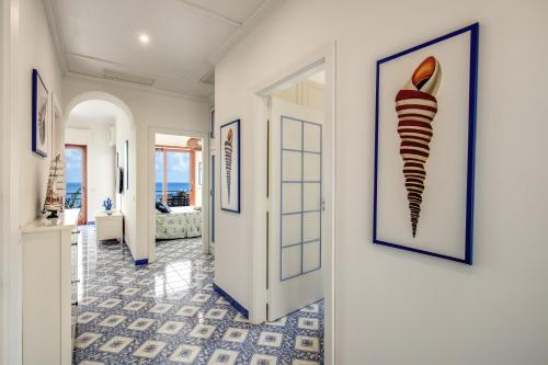 un pasillo con paredes blancas y un pasillo con una foto enmarcada de un calcetín a rayas en RELAIS TRITONE, en Nerano