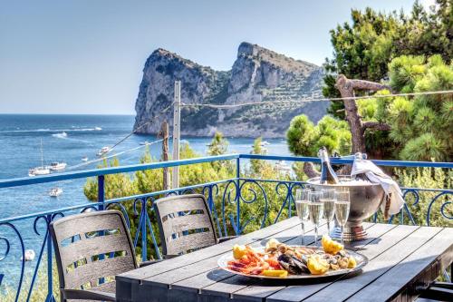 a plate of food on a table on a balcony with the ocean at RELAIS TRITONE in Nerano