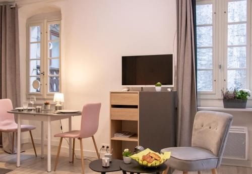 sala de estar con mesa y TV en Le Paquier - Avec Balnéo - Au Cœur d'Annecy - Majord'Home, en Annecy