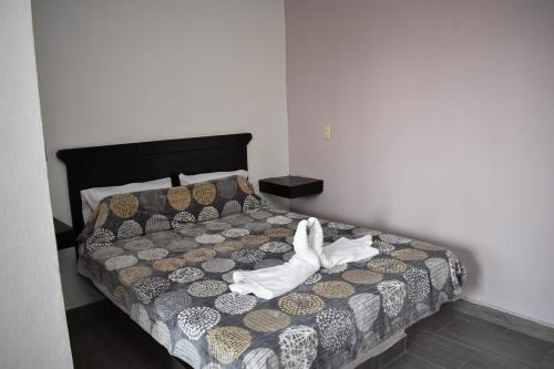 a bedroom with a bed with white shoes on it at HOTEL LOS PINOS CENTRO in Tuxtla Gutiérrez