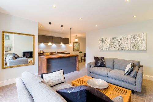 una sala de estar con un sofá y una mesa en Luxury Apartments - 22 Garden Flat, en Cheltenham