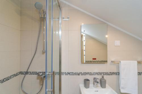 La salle de bains est pourvue d'une douche et d'un lavabo. dans l'établissement Sea View Studio Positive Place - II, à Dubrovnik