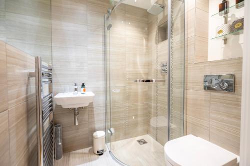 a bathroom with a shower and a toilet and a sink at I Should Cocoa (York) - Seebohm in York