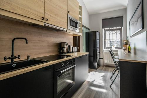 a kitchen with a sink and a stove at Stylish Apartments close to Eden Garden in Prague