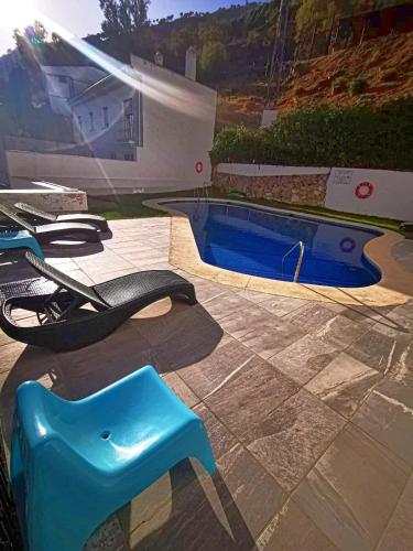 a swimming pool with a blue stool next to it at Apartamento Doña Pia in Mijas