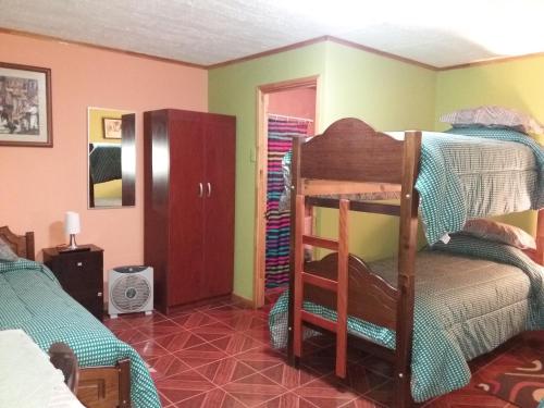 a bedroom with a bunk bed and a room with a ladder at Alojamiento Valle Verde in Isla de Maipo