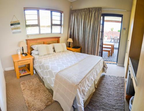 a bedroom with a bed and a door to a balcony at River Rooms - Chilled and Relaxed - Colchester - 5km from Elephant Park in Colchester