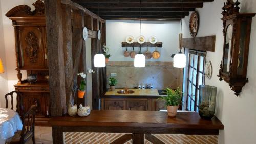 cocina con mesa de madera y fregadero en Le Relais de la Tour, en La Chaussée-Saint-Victor