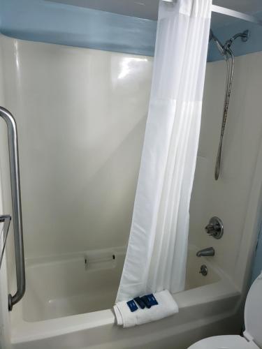 a bathroom with a shower with a shower curtain at Topaz Motel - Flagler Beach in Flagler Beach