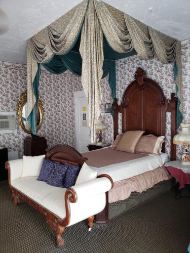 a bedroom with a canopy bed and a couch at Topaz Motel - Flagler Beach in Flagler Beach