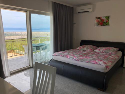 a bedroom with a bed and a balcony with a view at Apartments Diana in Šmrika