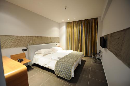 a hotel room with a bed and a television at Hotel Iliana in Filippiada