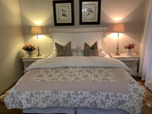 a bedroom with a large bed with two tables and two lamps at KarMichael Farm in Himeville