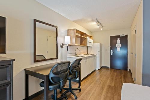 a kitchen with a desk and two chairs in a room at Extended Stay America Premier Suites - San Francisco - Belmont in Belmont