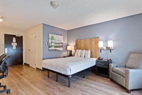 a hotel room with a bed and a chair at Extended Stay America Premier Suites - San Francisco - Belmont in Belmont