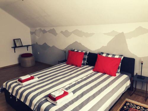 um quarto com uma cama grande e almofadas vermelhas em Artisan House Meraki em Udbina