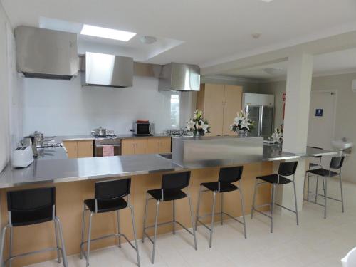 a kitchen with a counter and bar stools at Perth 178 Backpackers in Perth
