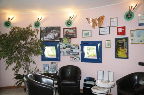 a waiting room with two chairs and butterflies on the wall at Hotel Il Canneto in Porto Ceresio