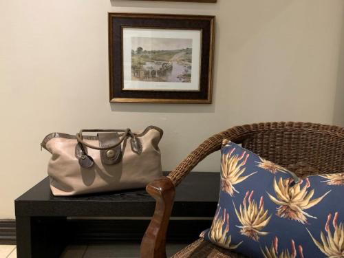 a purse sitting on a table next to a chair with a pillow at KarMichael Farm in Himeville