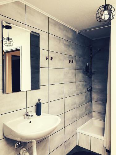 a bathroom with a sink and a mirror and a tub at Artisan House Meraki in Udbina