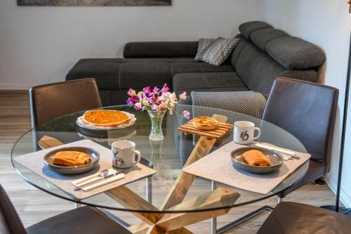 a glass table with food on it in a living room at Swiss Lake Lodge in Noville