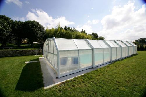 un gran invernadero de cristal en un campo de hierba en Casa da Botica A Estrada, en Os Casares