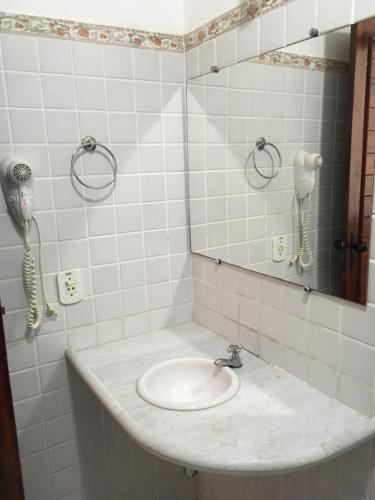 a bathroom with a sink with a mirror and a phone at Hotel Pousada Dos Ventos in Parnaíba