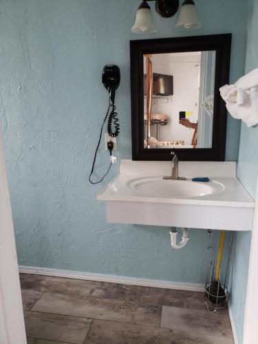 a bathroom with a sink and a mirror at Topaz Motel - Flagler Beach in Flagler Beach