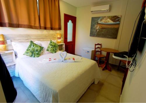 a bedroom with a white bed in a room at Pousada Vila Boa Vida in Bombinhas
