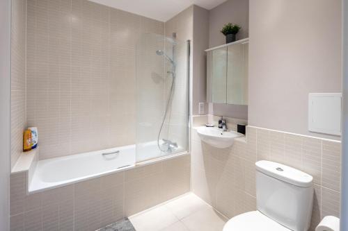 a bathroom with a toilet and a shower and a sink at Vertex Luxury Suite in Croydon