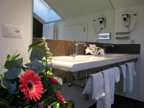 a bathroom with a sink and a large mirror at Hotel d'Allèves in Geneva