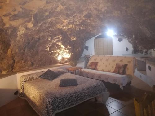 a bedroom with a bed and a couch in a cave at Casa cueva El perucho in Güimar