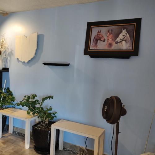una habitación con dos mesas y una foto de caballos en la pared en Travel Inn, en Delaware