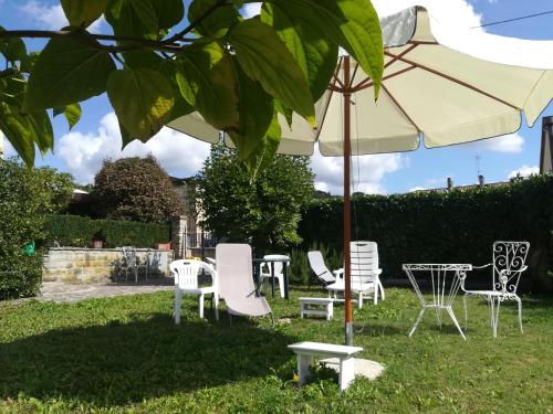a group of chairs and an umbrella in the grass at Casa Giulia in Ronta
