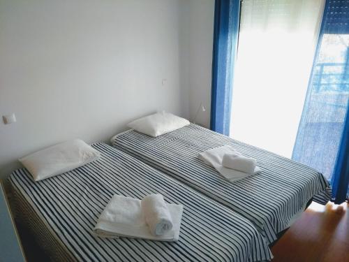 two beds with towels on them in a bedroom at Faro Island Beach & Airport Apartment in Faro